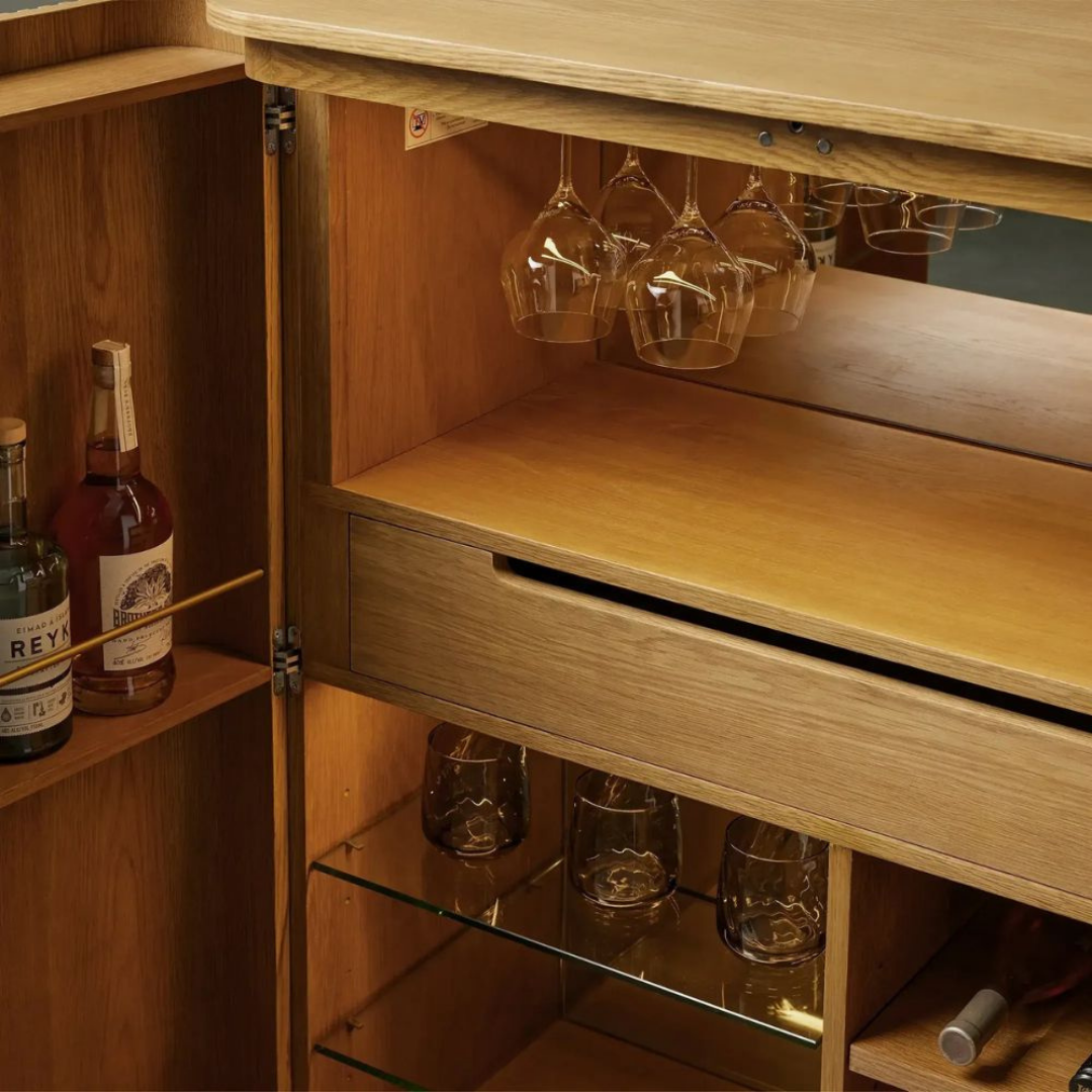 Modern wooden bar cabinet with double doors, bottle storage, wine glass holder, shelves, and home bar storage design.